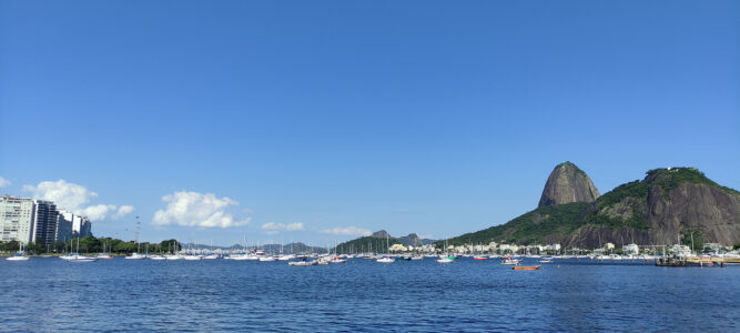 Praia de Botafogo, com o Pão de Açúcar se erguendo à direita. Praia Botafogo